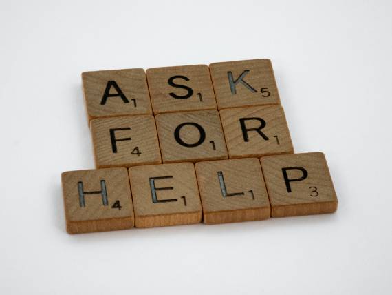 Ask for help written in scrabble tiles